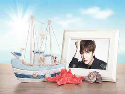 Khung ảnh chân dung nằm đặt cạnh con thuyền ốc biển và san hồ