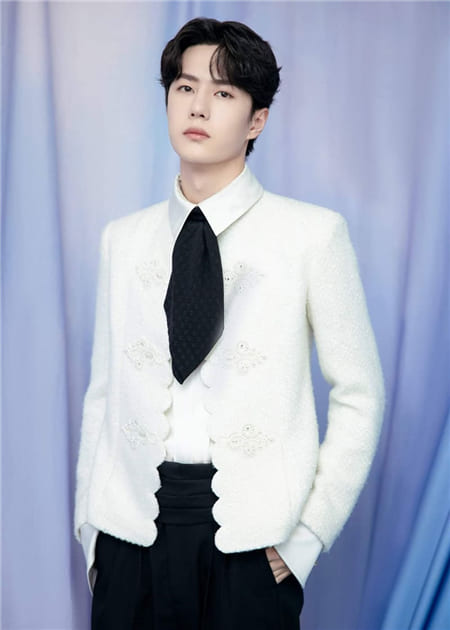 Hình ảnh diễn viên Trung Quốc Vương Thiên Bắc với chiếc áo khoác trắng và chiếc nơ đen lạ mắt
