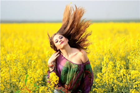 Hình ảnh cô gái xinh đẹp đắm mình trên cánh đồng hoa vàng rực rỡ làm hình nền máy tính
